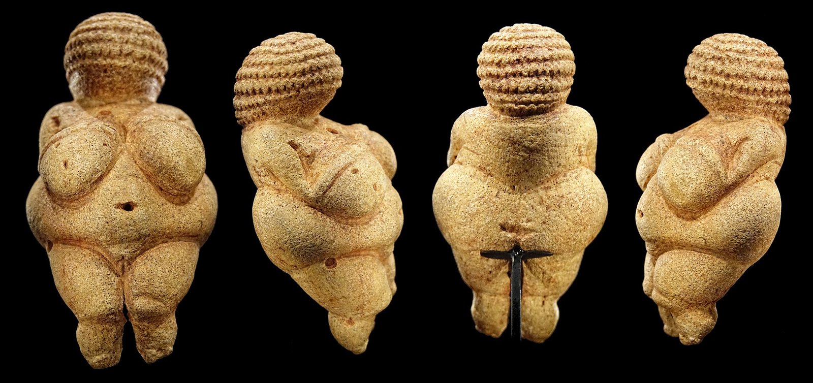 A photo showing the Venus of Wilendorf — a small ancient stone statue depicting a round human with a rounded belly and breasts.